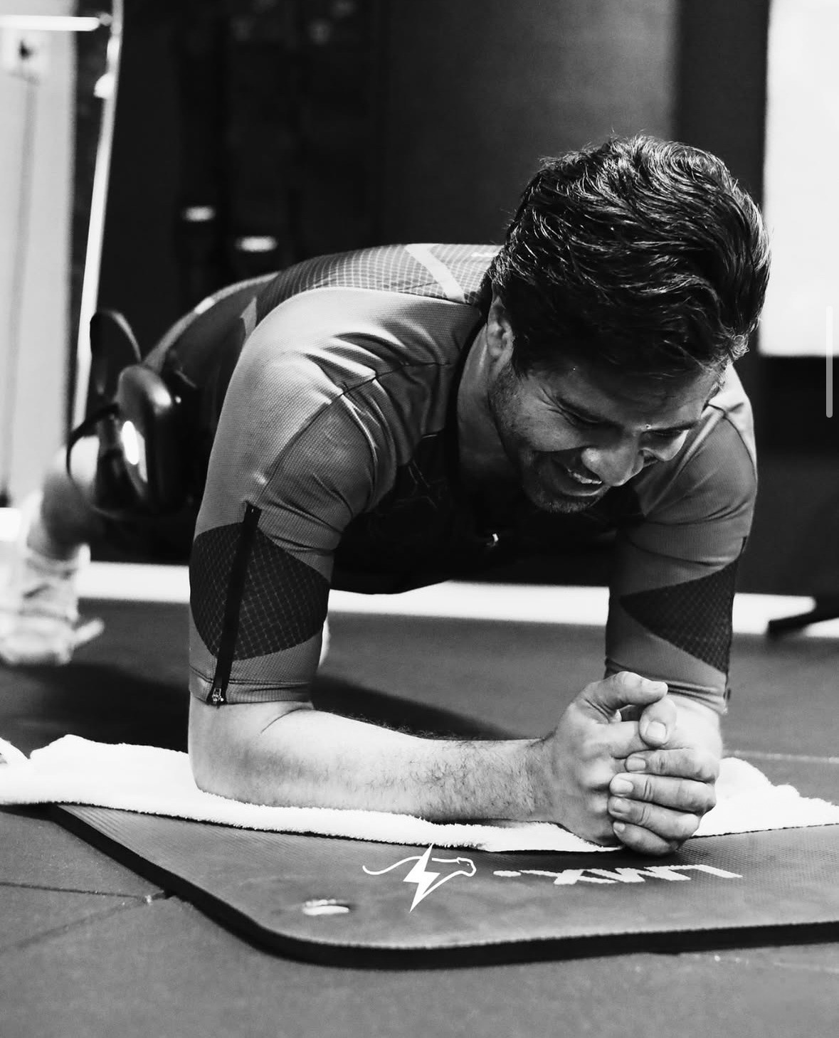Man doet een planke-oefening op een mat in de sportschool